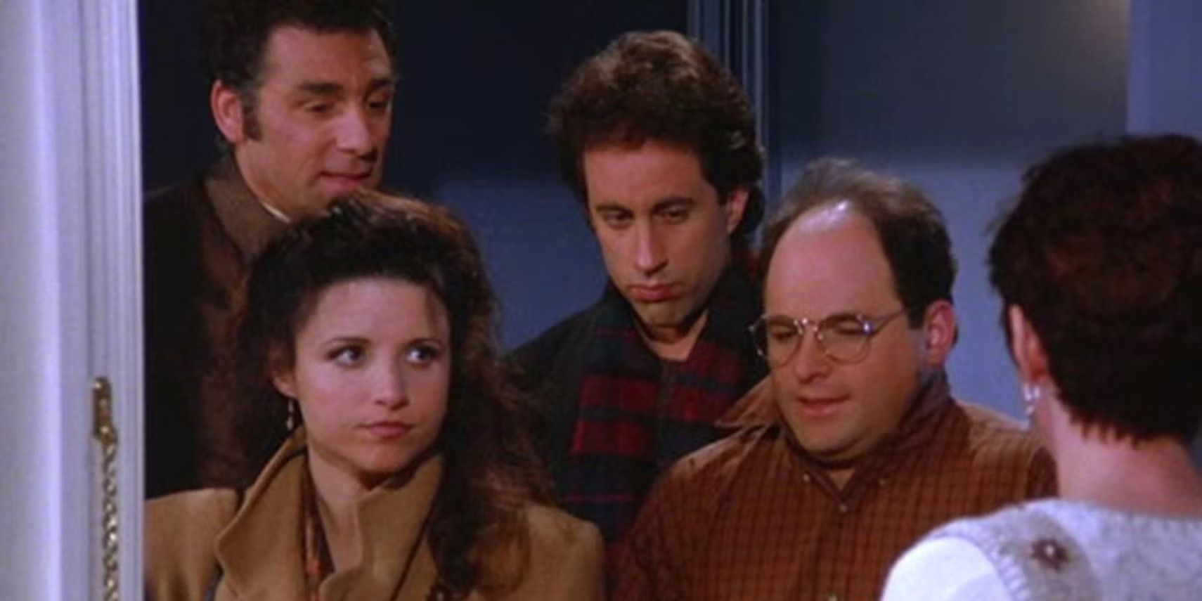 Jerry, Elaine, George et Kramer ont l'air mécontents de se tenir debout dans une porte à Seinfeld.