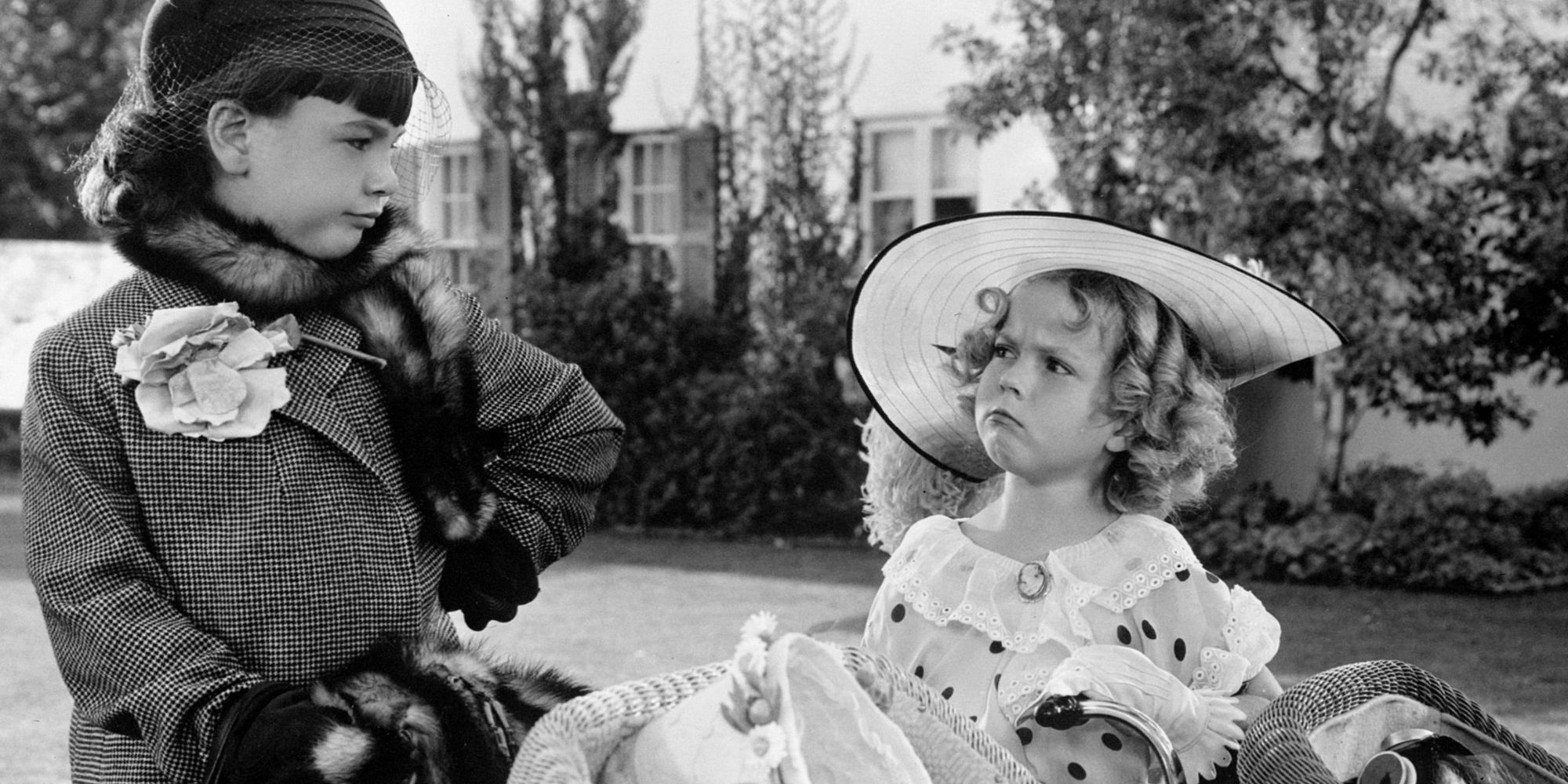 Shirley Temple looking at Jane Withers standing next to her in Bright Eyes (1934)