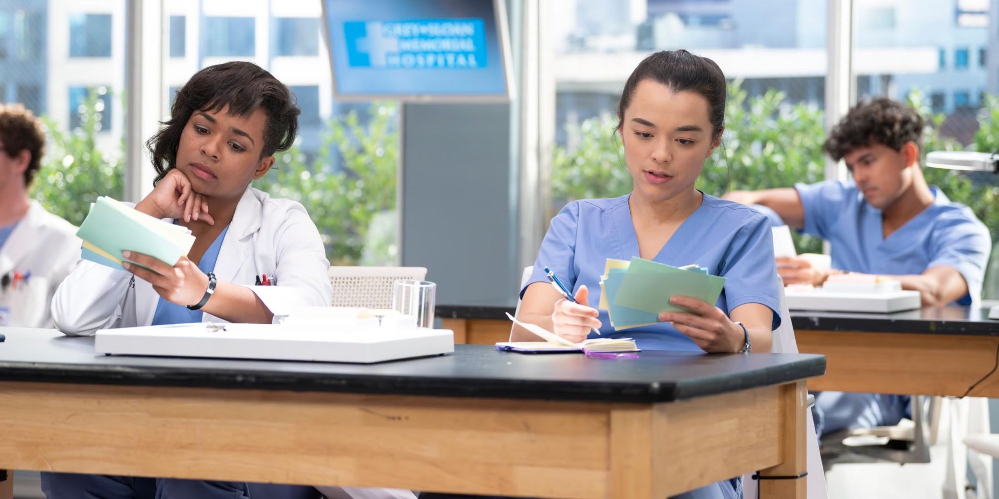 Alexis Floyd & Midori Francis as Simone & Mika in Grey's Anatomy sitting at a table looking at flash cards.