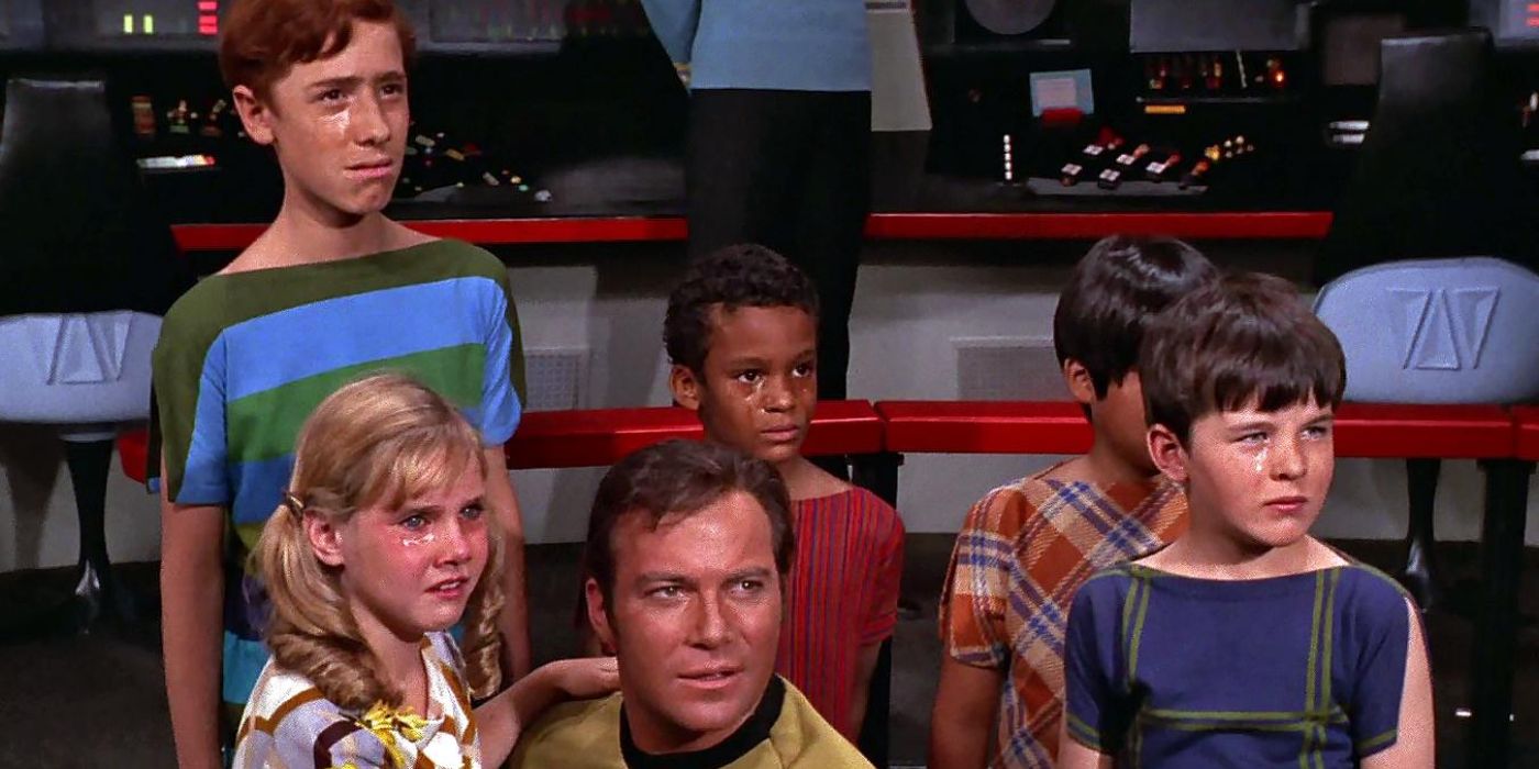 Kirk holds a young child in his arms and is surrounded by other children who were crying on Star Trek.