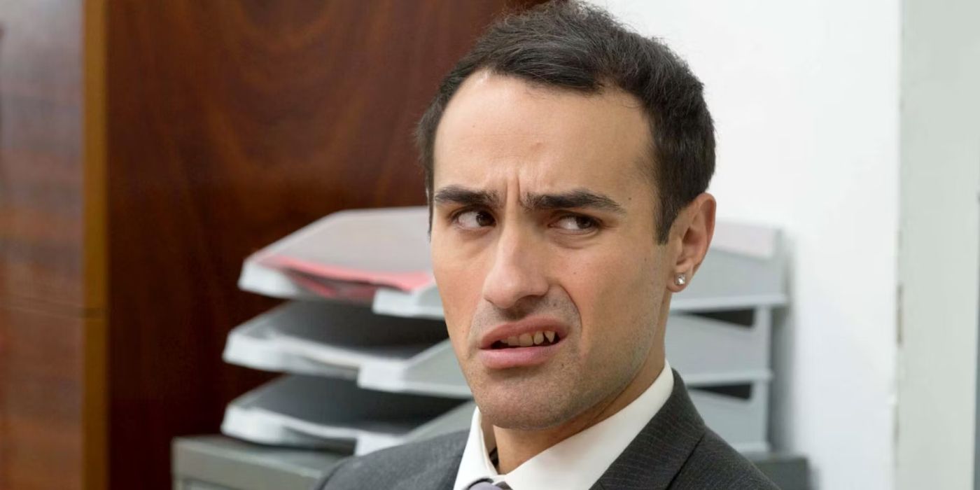 Jamie Demetriou as Stath giving someone the side-eye in an office in 'Stath Lets Flats'.