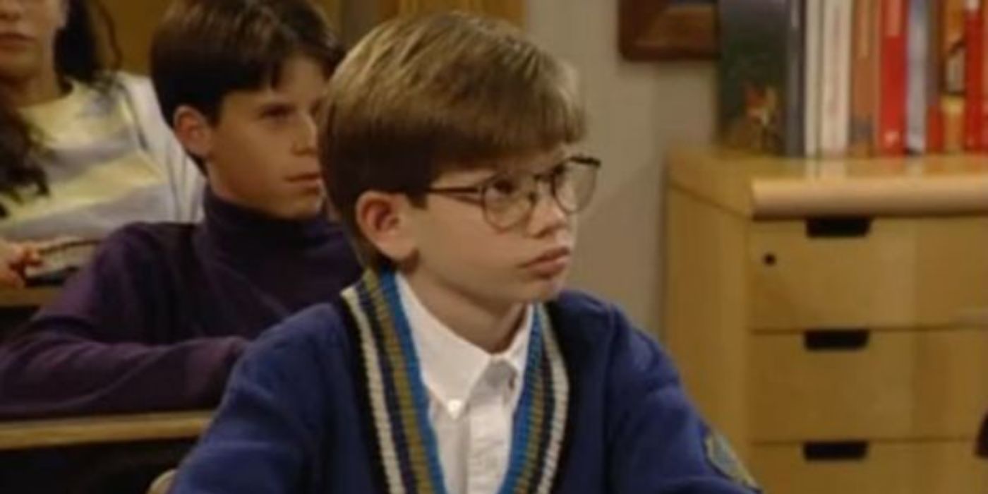 Stuart Minkus sitting at a desk in class in Boy Meets World.