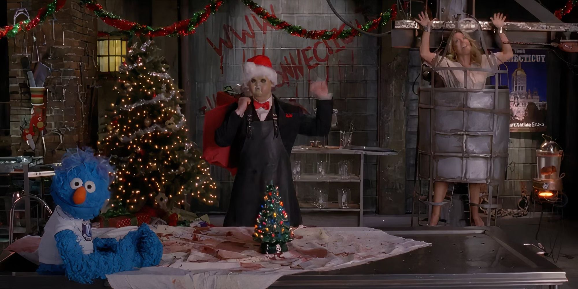 Jenna Maroney in a cage on the wall with a man dressed as Santa in a scary mask and a puppet at a table in 30 Rock.