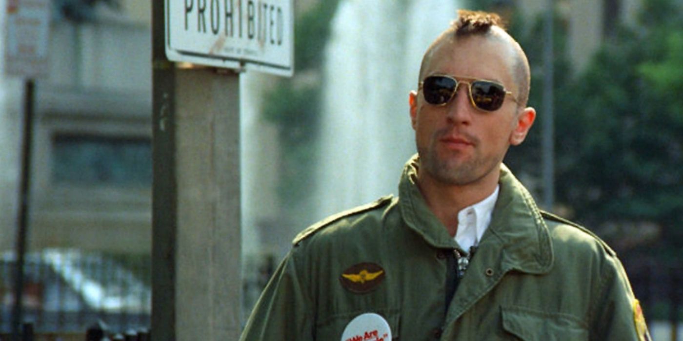 Travis Bickle (Robert De Niro) stands in the street wearing sunglasses and sporting a rough mohawk in 'Taxi Driver' (1976).