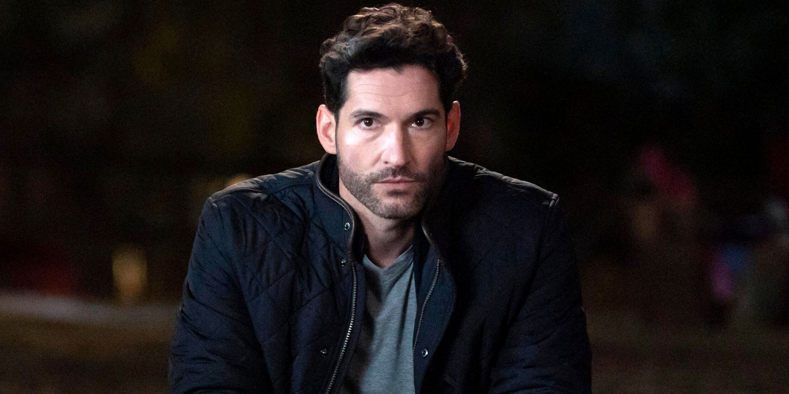 Tom Ellis as Oliver leaning forward and looking into the camera in Season 2 of Tell Me Lies