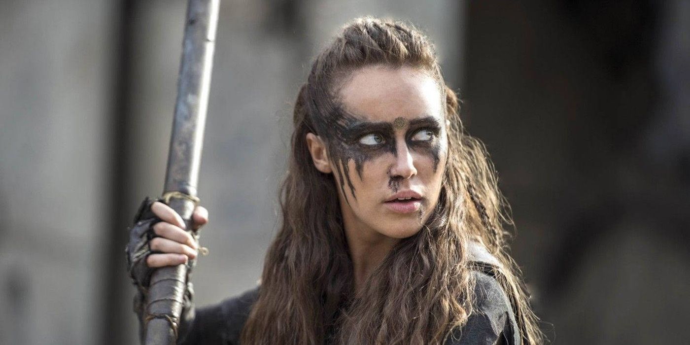 Alycia Debnam-Carey as Lexa holding a long weapon with face paint in The 100.