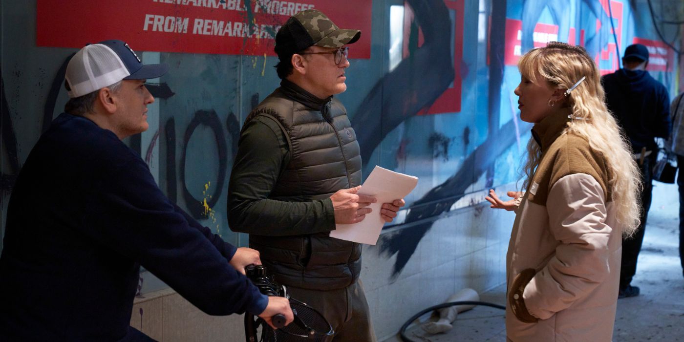 Joe and Anthony Russo talking to Millie Bobby Brown on the set of The Electric State.