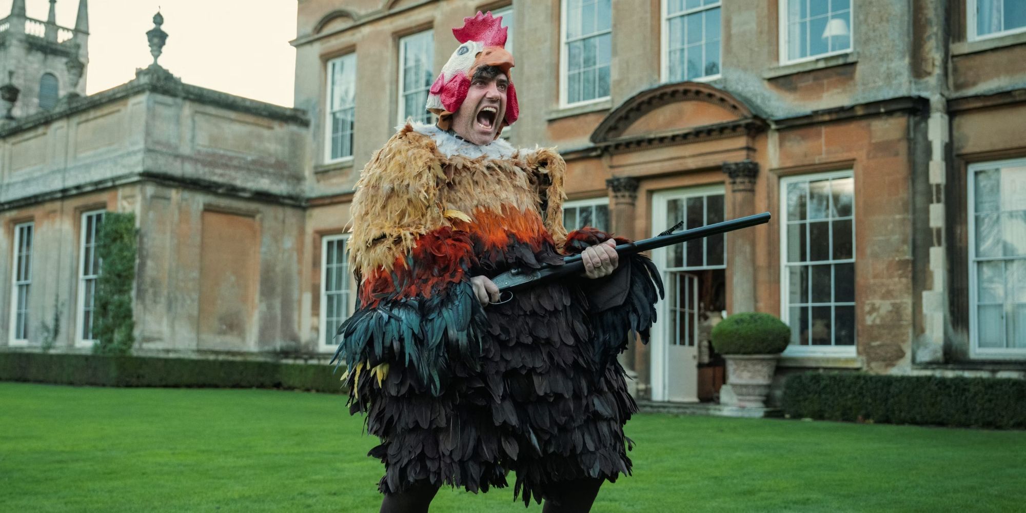 Daniel Ings as Freddy in a chicken suit with feathers and a shotgun in Episode 2 of Season 1 of The Gentlemen.