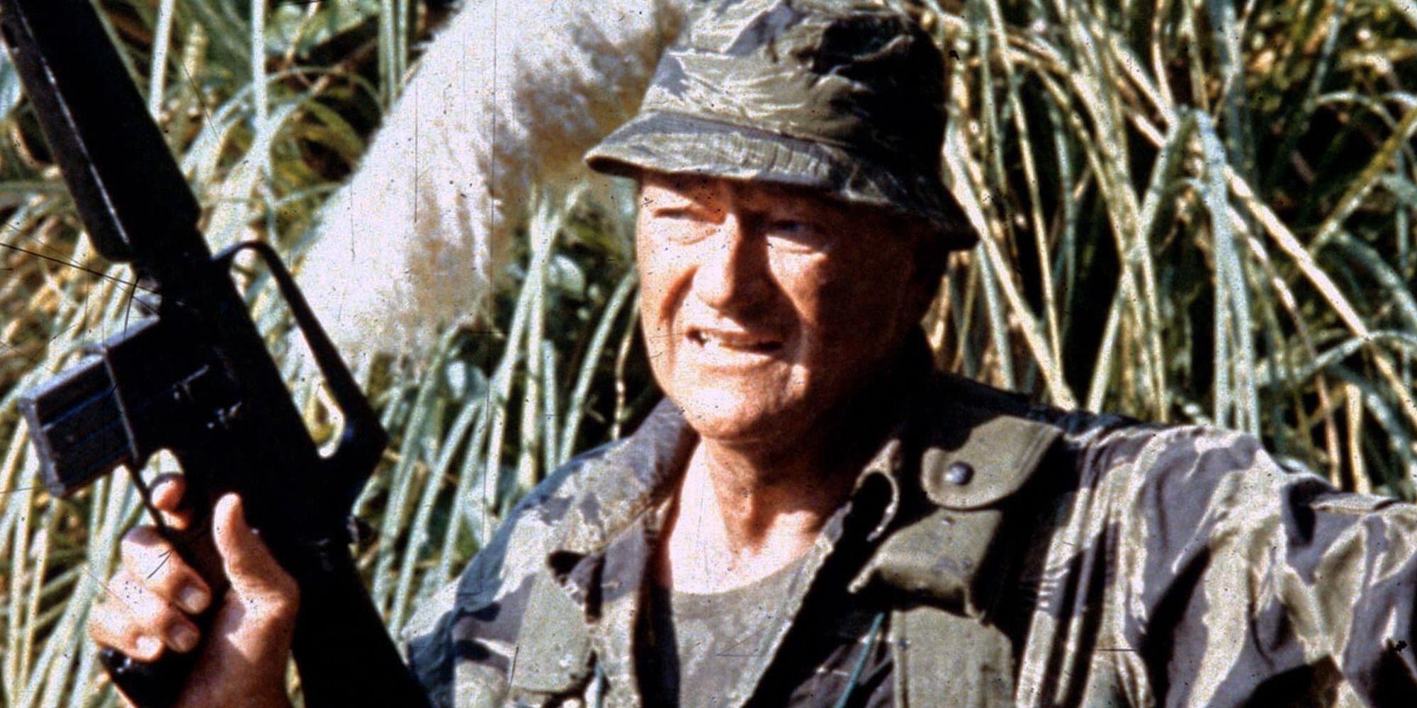 John Wayne holding a rifle in 'The Green Berets'