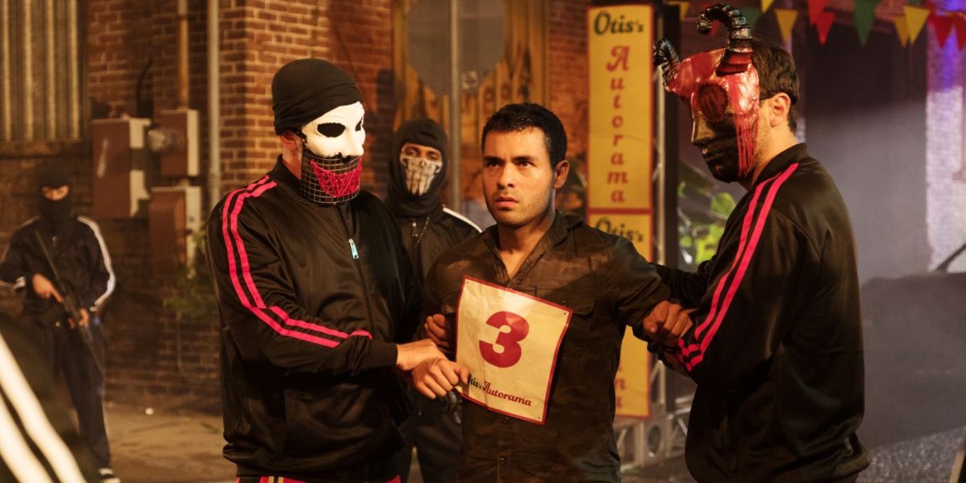 Two men in masks holding a #3 sign on the chest of another guy in The Purge