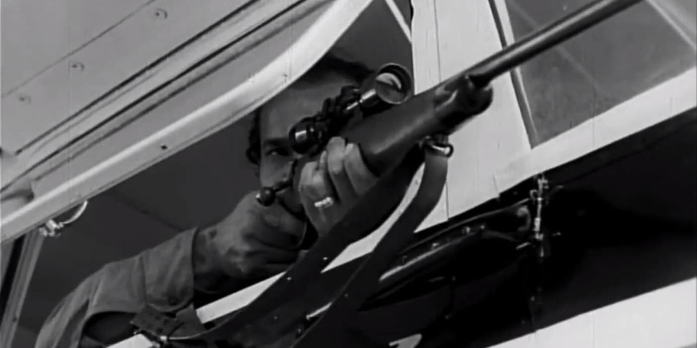 A man pointing a rifle outside the window of an RV in 'The Beast of Yucca Flats' 