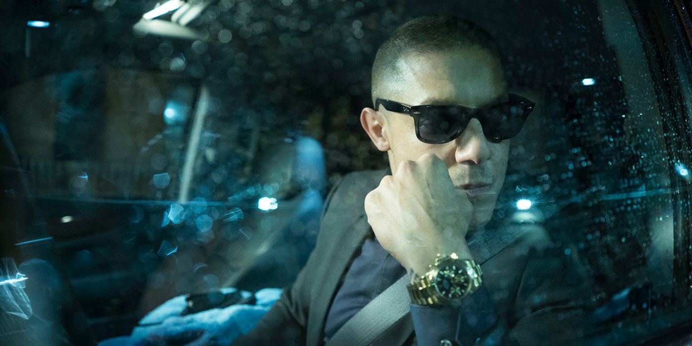 Theo Rossi staring through a car window with shades on and a gold watch on his wrist