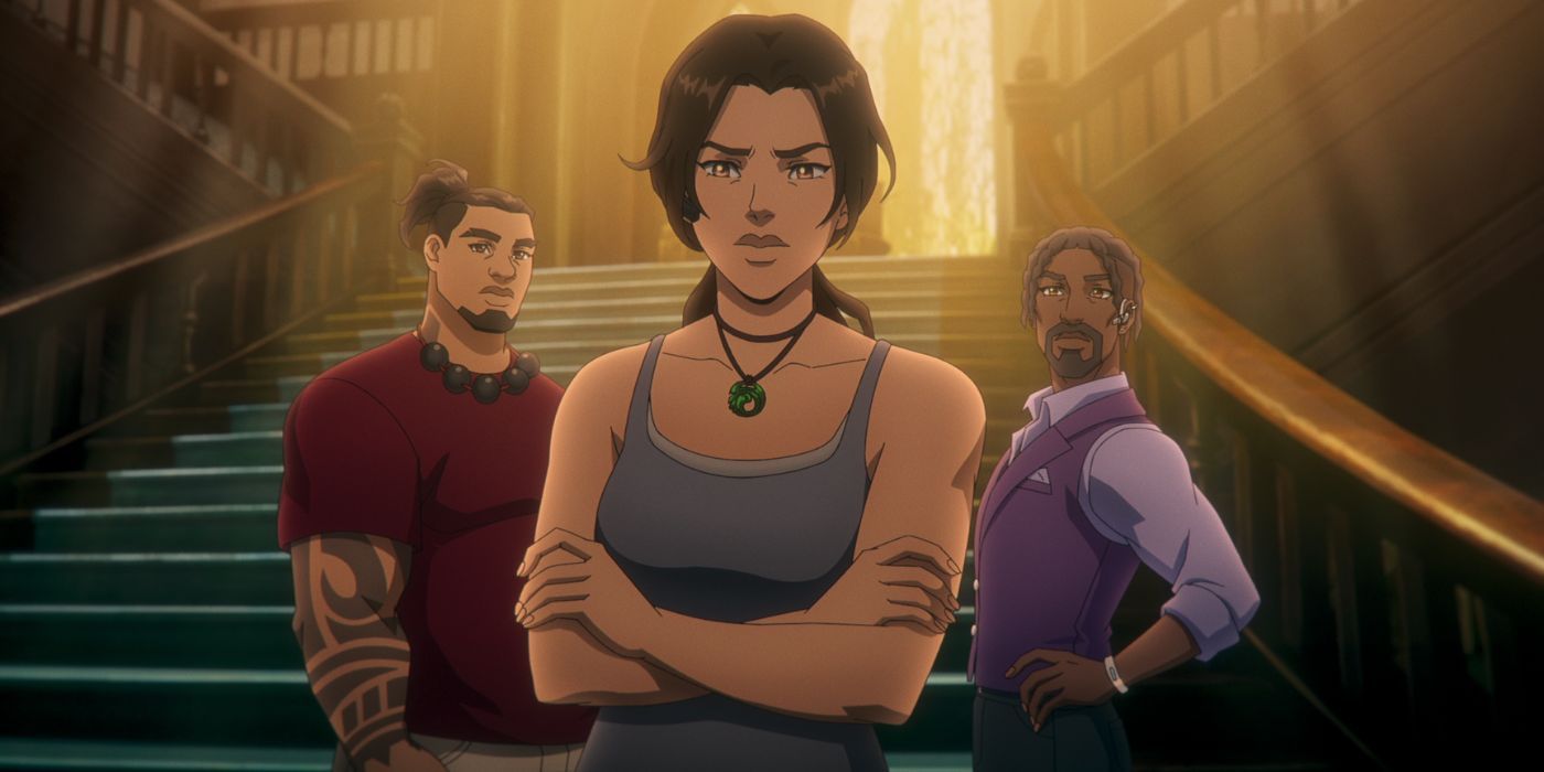 Lara Croft (Hayley Atwell) standing at a stairwell with her arms folding as Jonah (Earl Baylon) and Zip (Allen Maldonado) stand behind her.