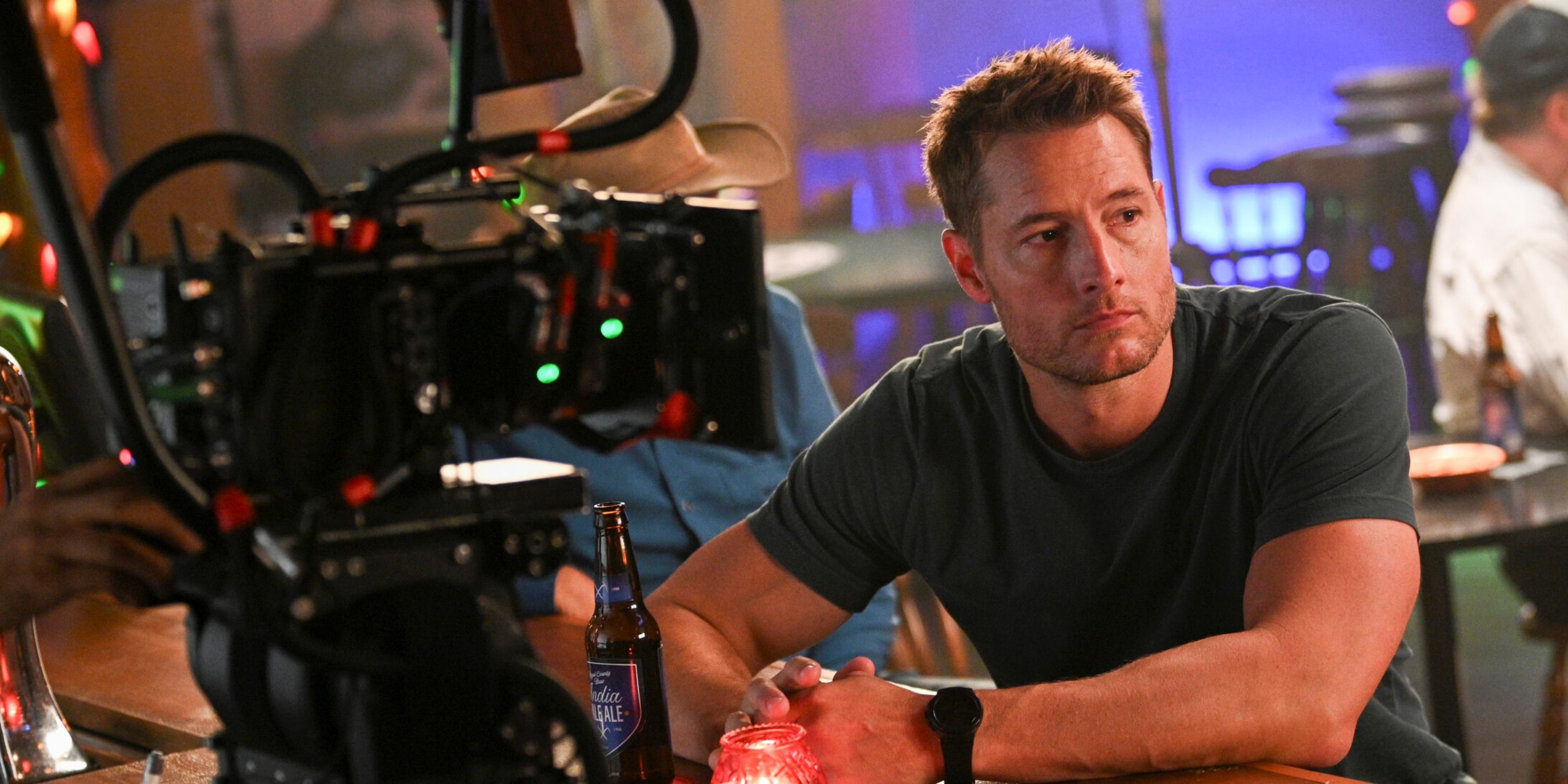 Justin Hartley as Colter Shaw sitting at a table while shooting a scene for Season 2 of Tracker