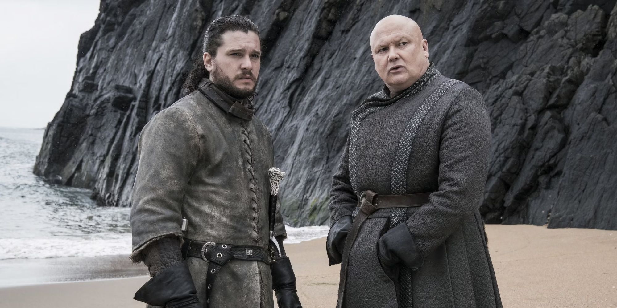 Lord Varys (Conleth Hill) and Jon Snow (Kit Harington) on a beach in Game of Thrones.