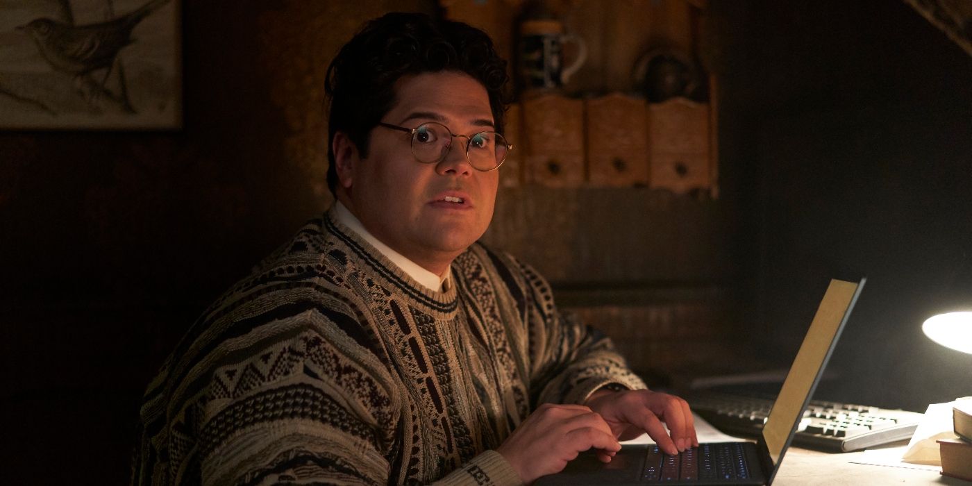 Harvey Guillen sitting under the stairs with a laptop