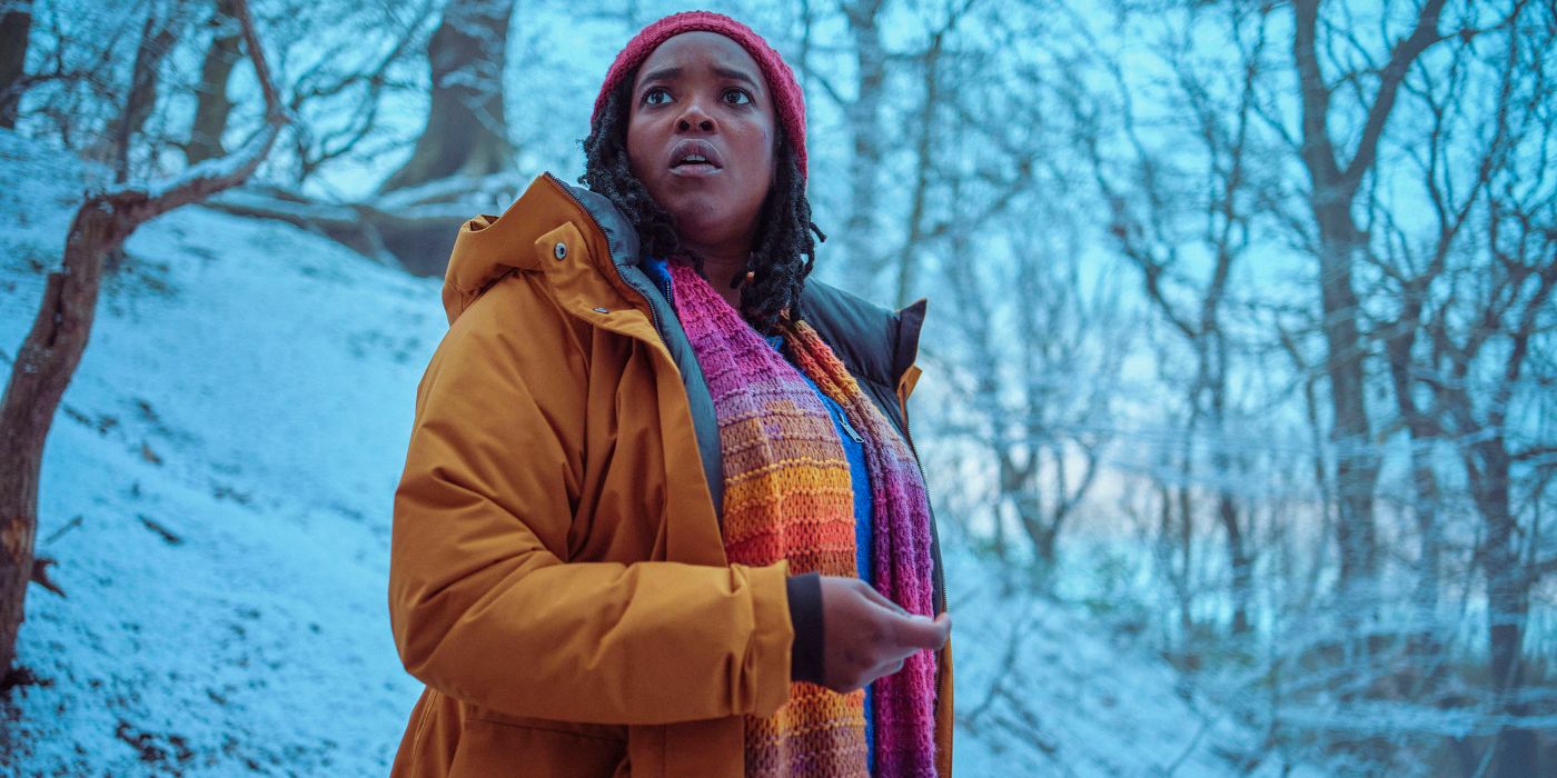 Wunmi Mosaku looking shocked as she holds something in the snowy forest in Passenger