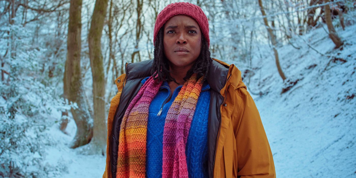 Wunmi Mosaku staring out toward the camera at the distance in a snowy forest in Passenger