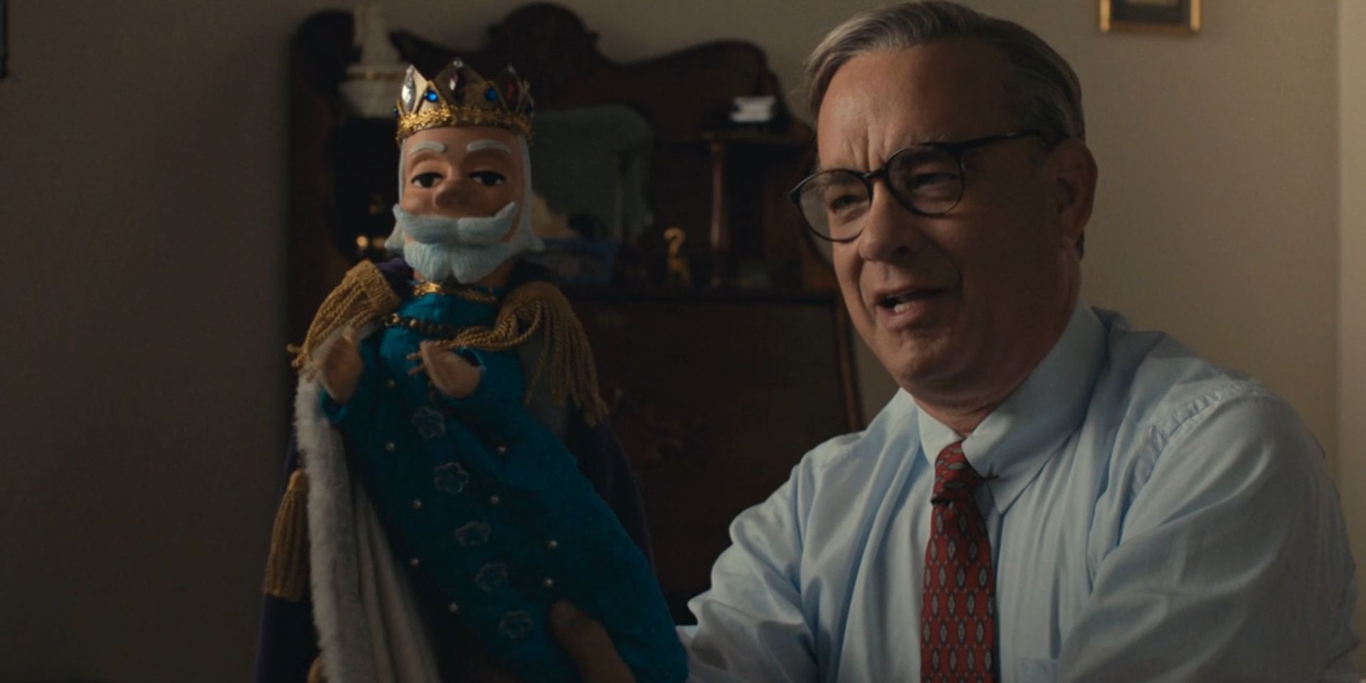 Fred Rogers, played by Tom Hanks, holds up King Friday XIII in 'A Beautiful Day in the Neighborhood'.