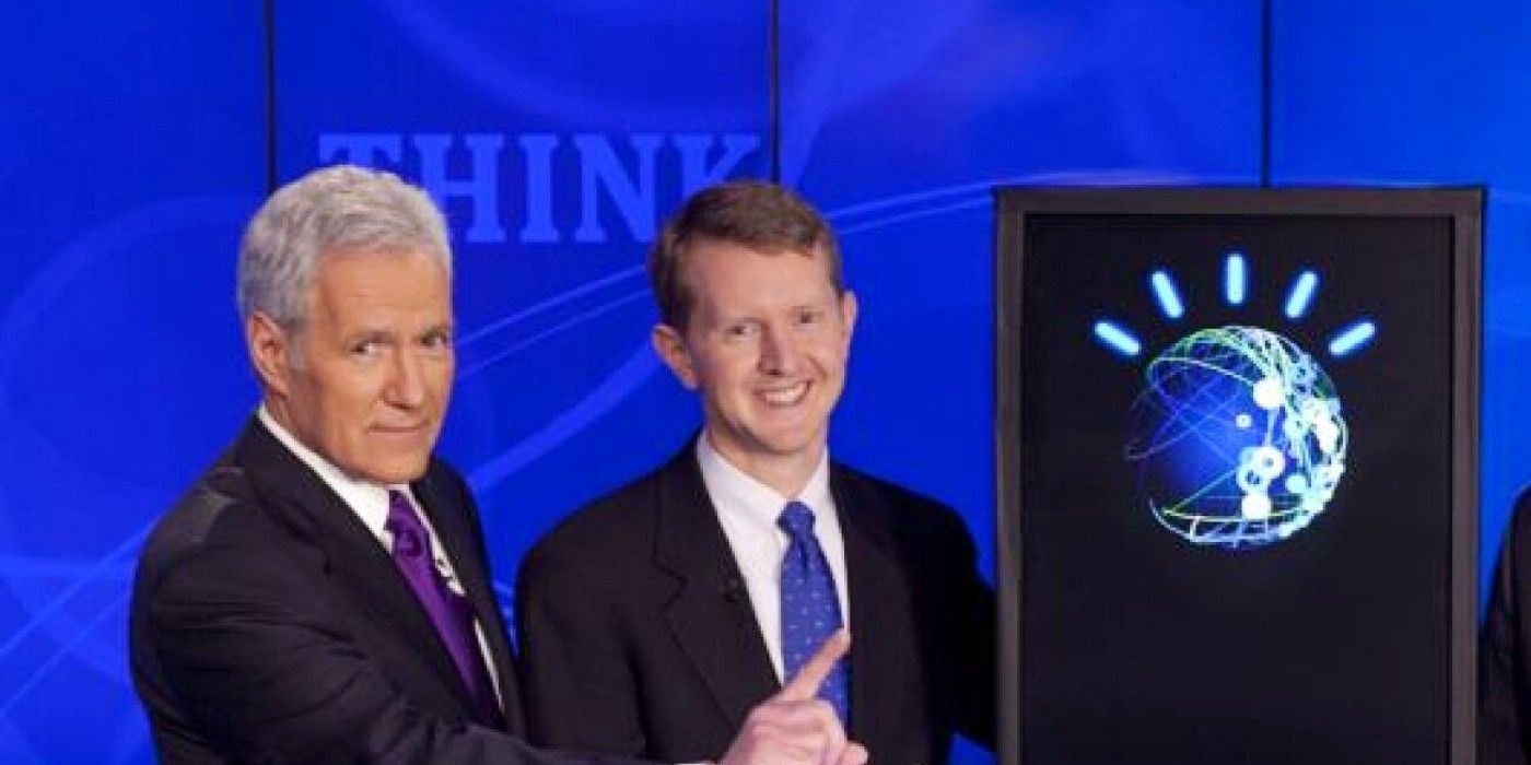 Alex Trebek, Ken Jennings, Watson the robot, and Brad Rutter standing together on Jeopardy!-1