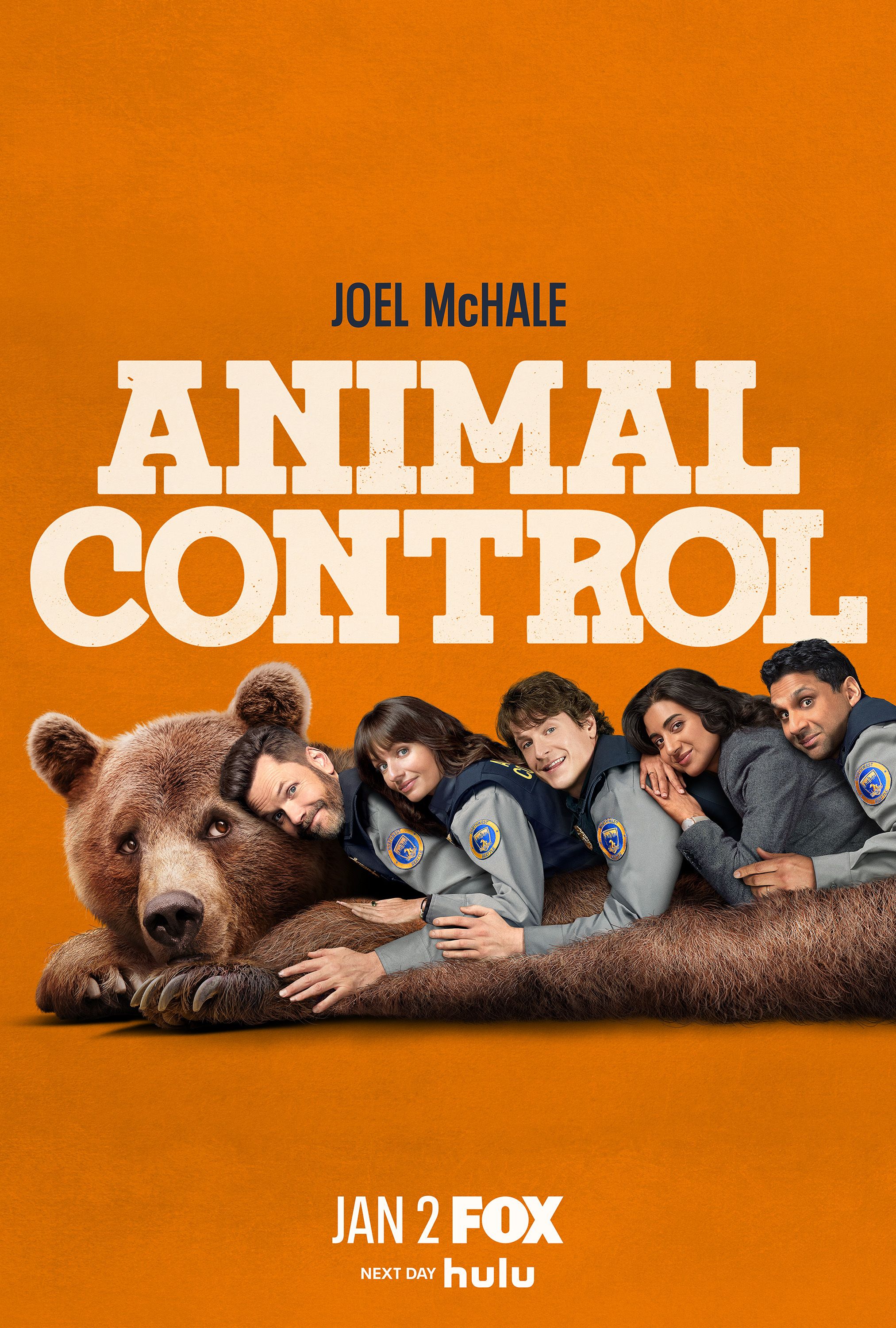 Joel McHale and the rest of the cast of 'Animal Control' lay on top of a bear in the S3 poster for 'Animal Control'