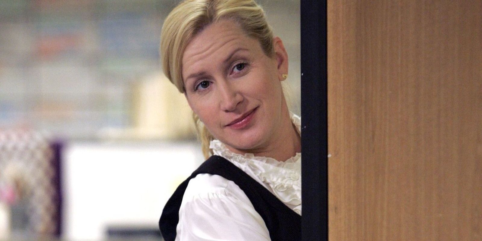 Angela Kinsey peeking out from behind a door in The Office.