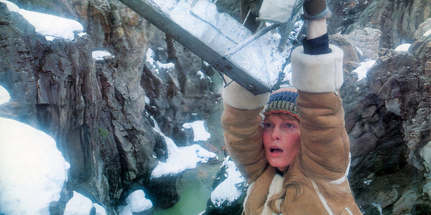Mia Farrow as Caroline hangs onto a piece of metal on a snowy cliffside in Avalanche.