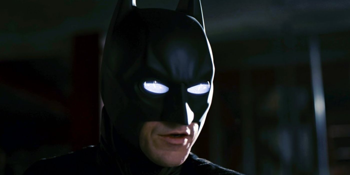 Batman in a warehouse with glowing white eyes in The Dark Knight