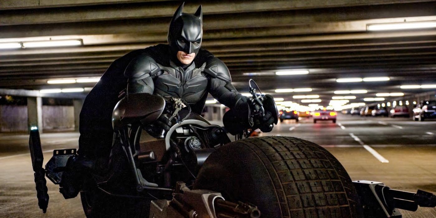 Batman on his Bat-Bike in a tunnel grimacing in The Dark Knight Rises