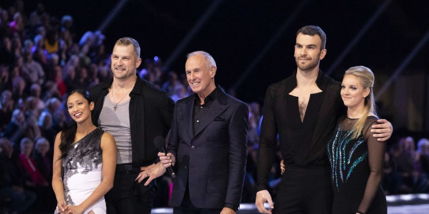 Contestants stand with their partners next to the host as they wait for scores on Battle of the Blades.