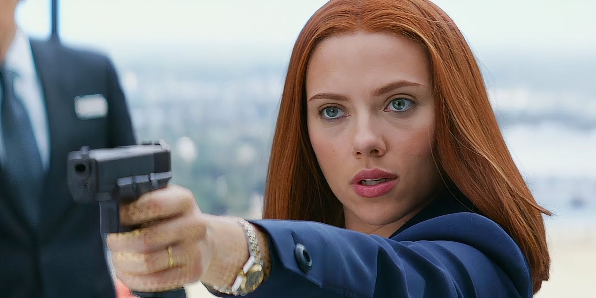 Black Widow holds a weapon after revealing herself from a disguise in Captain America: The Winter Soldier.