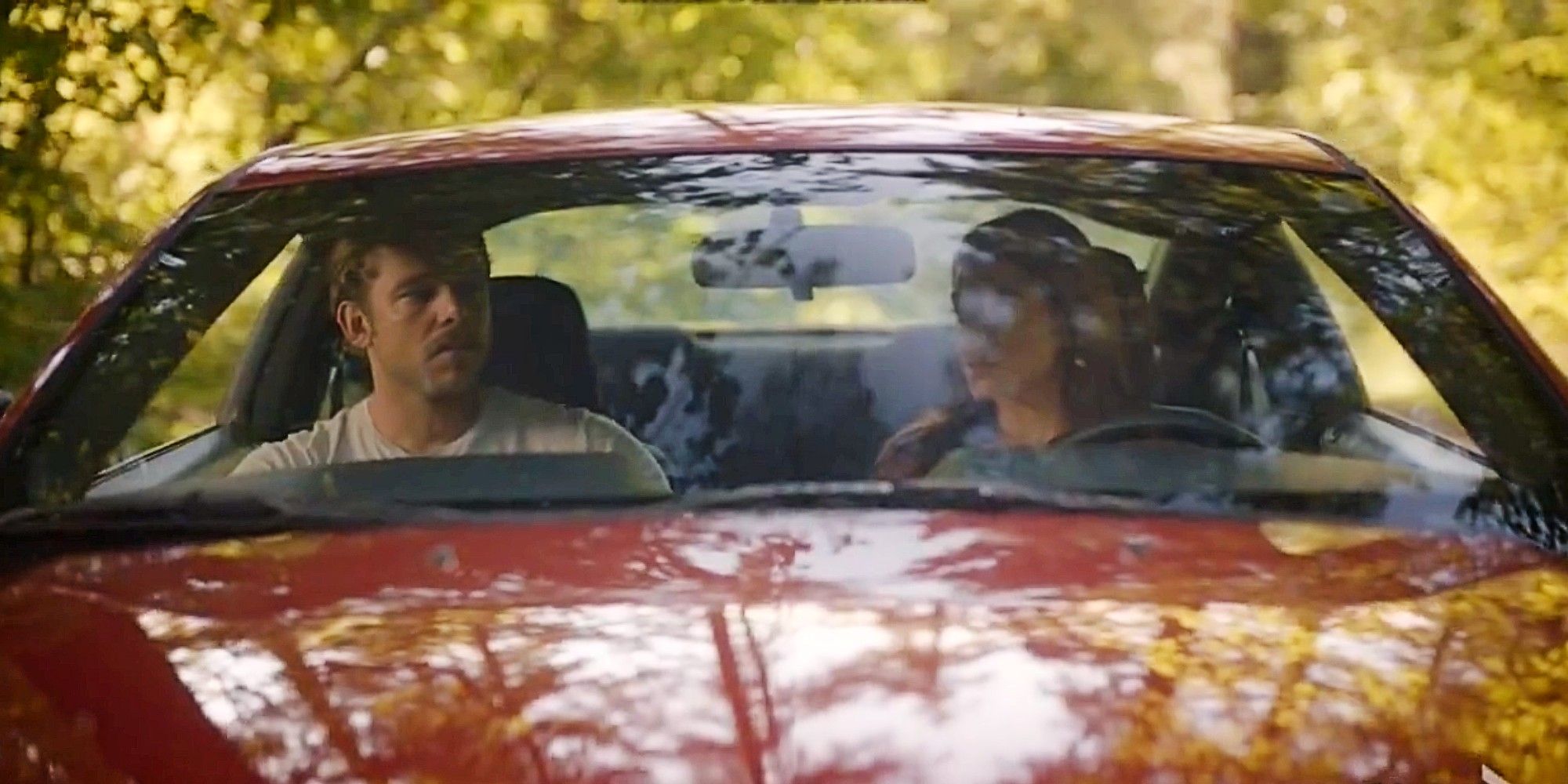 Bode Leona and Gabriela Perez sitting in a red car together and both looking solemn in Fire Country Season 3