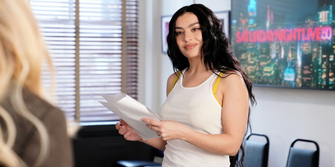 Charli XCX in a tanktop holding a script in the SNL offices.