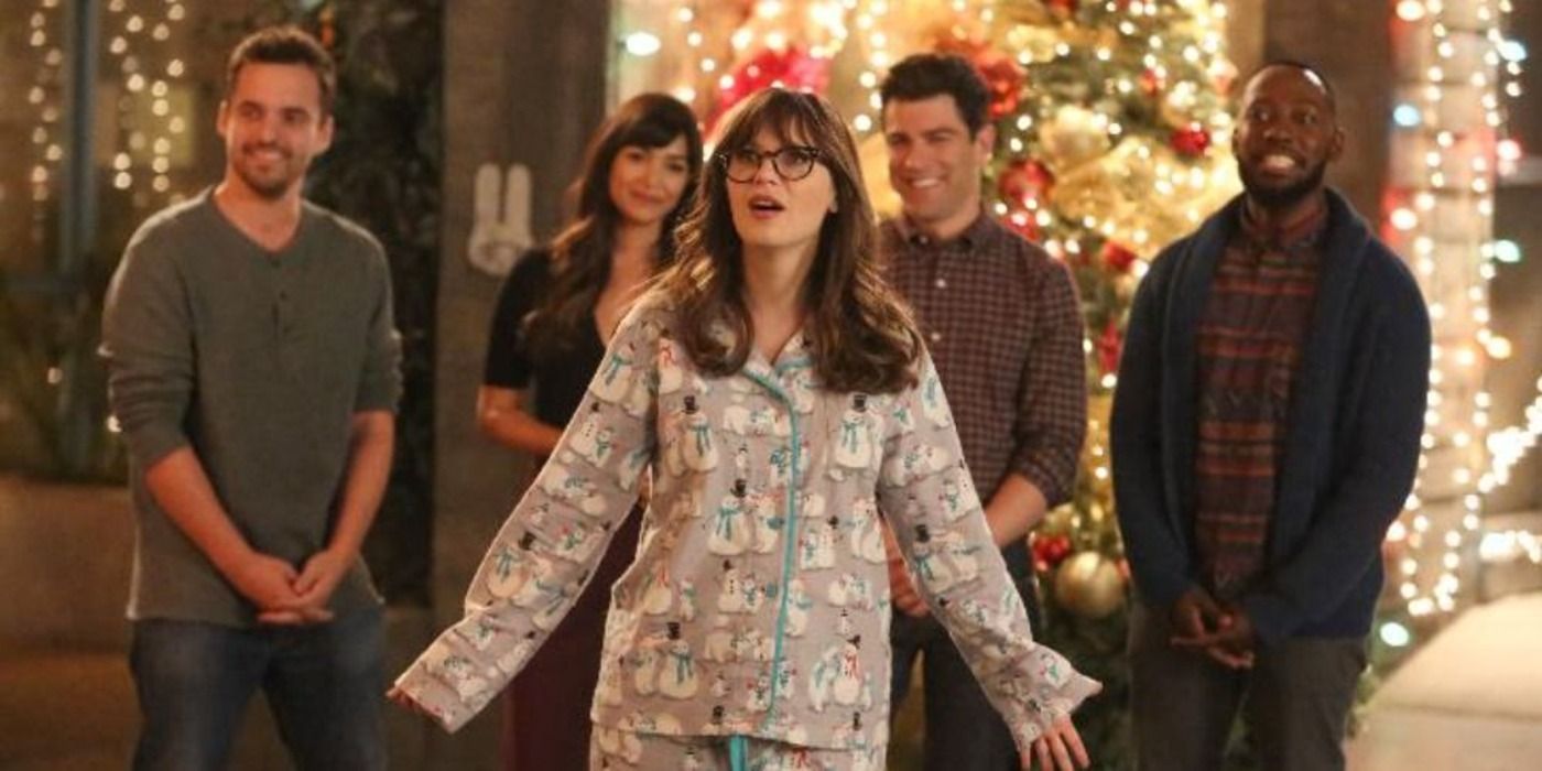 The cast stand oustide with festive decorations behind them in Christmas Eve Eve on New Girl.