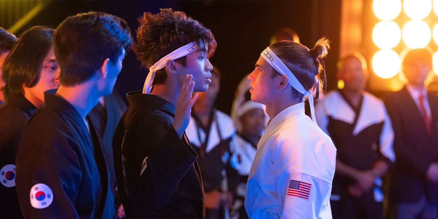 Kwon (Brandon H. Lee) standing with his hand raised in front of Robby (Tanner Buchanan) in uniform