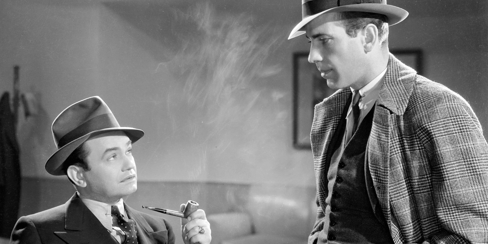 Edward G. Robinson sitting down looking up at Humphrey Bogart standing in front of him in Bullets or Ballots (1936)