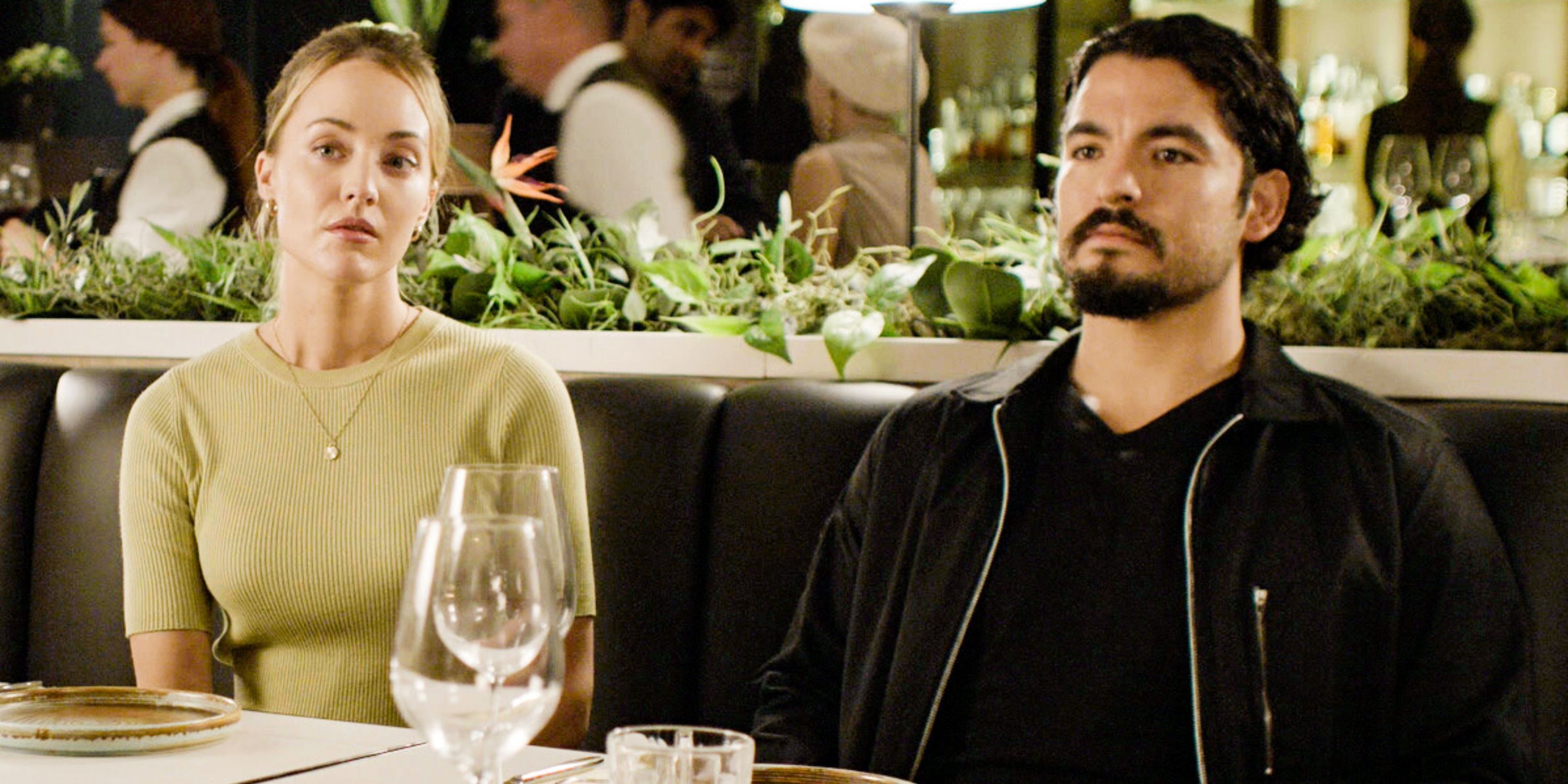 Christina Wolfe as Tate with Bobby Soto as Lopez sitting next to each other at dinner in FBI: International