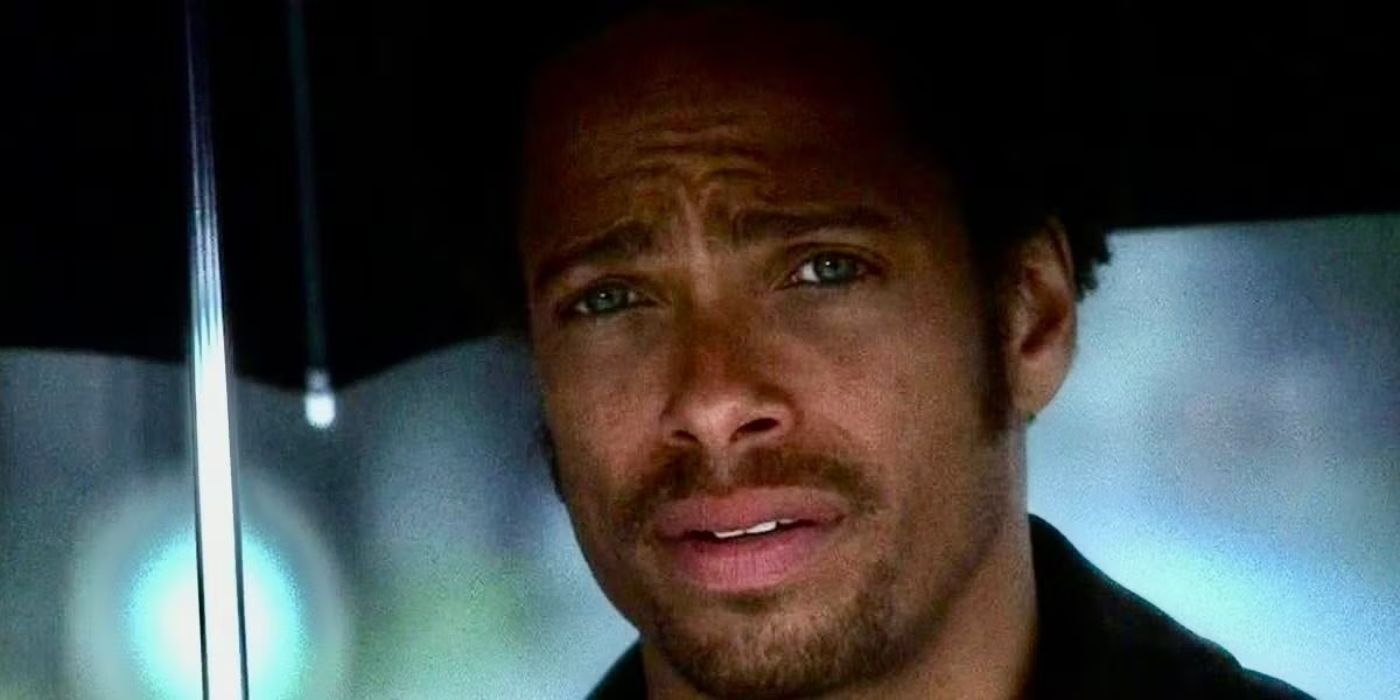 Gary Dourdan, who plays Warrick Brown, stands under an umbrella with a sad expression on his face in CSI.