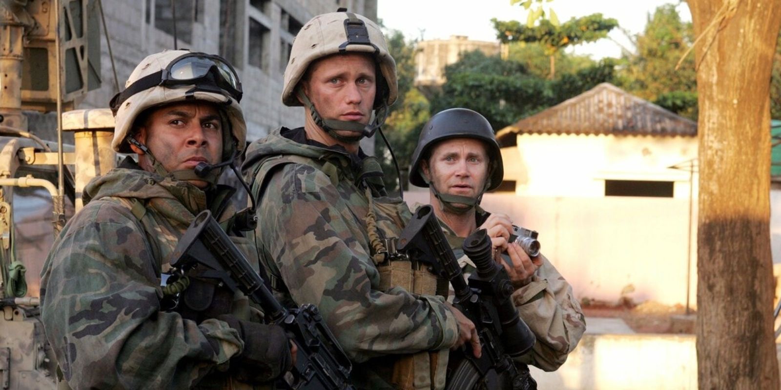 Two American soldiers and a journalist holding a camera stand in a street in Baghdad in 'Generation Kill' (2008).