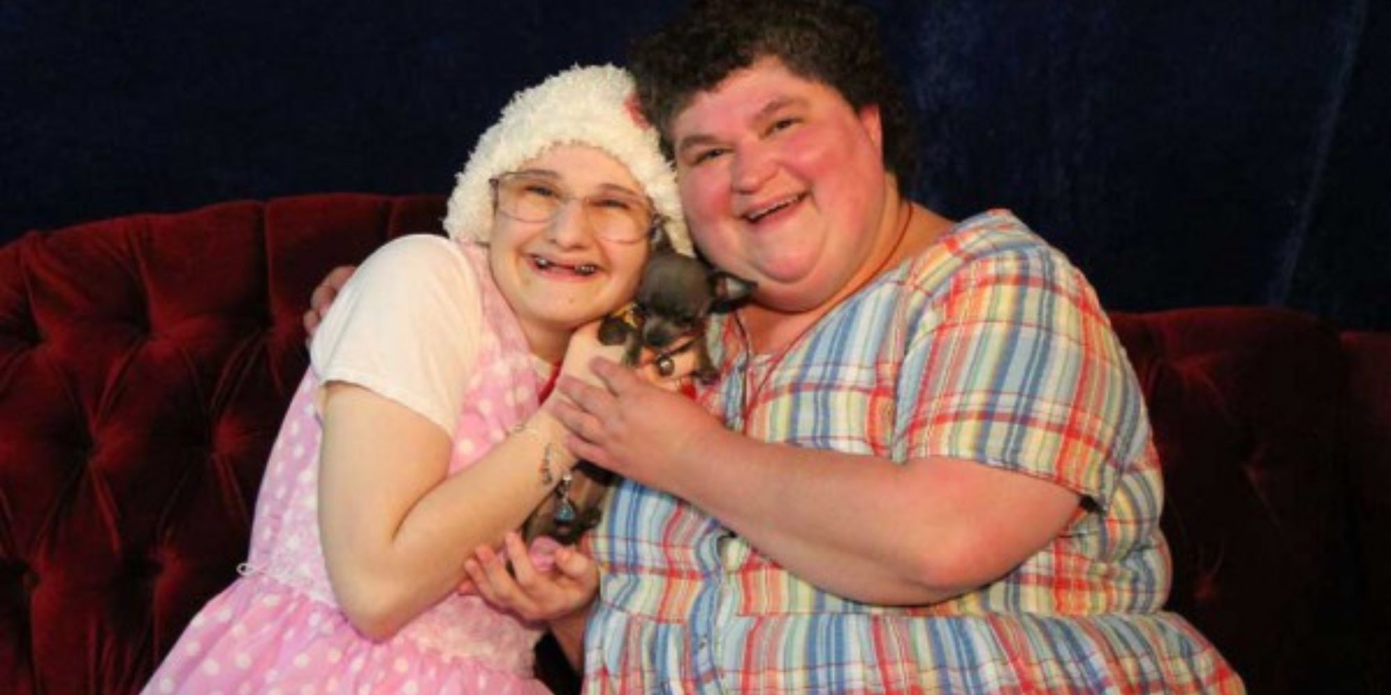 Gypsy Rose Blanchard sitting next to her mom DeeDee Blanchard both holding a puppy in between them in Mommy Dead and Dearest (2017)