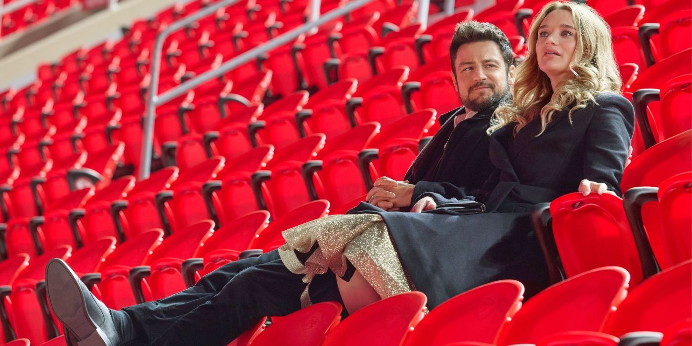 Tyler Hynes as Derrick and Hunter King as Alana sit in Arrowhead Stadium in a scene from 'Holiday Touchdown: A Chiefs Love Story.'