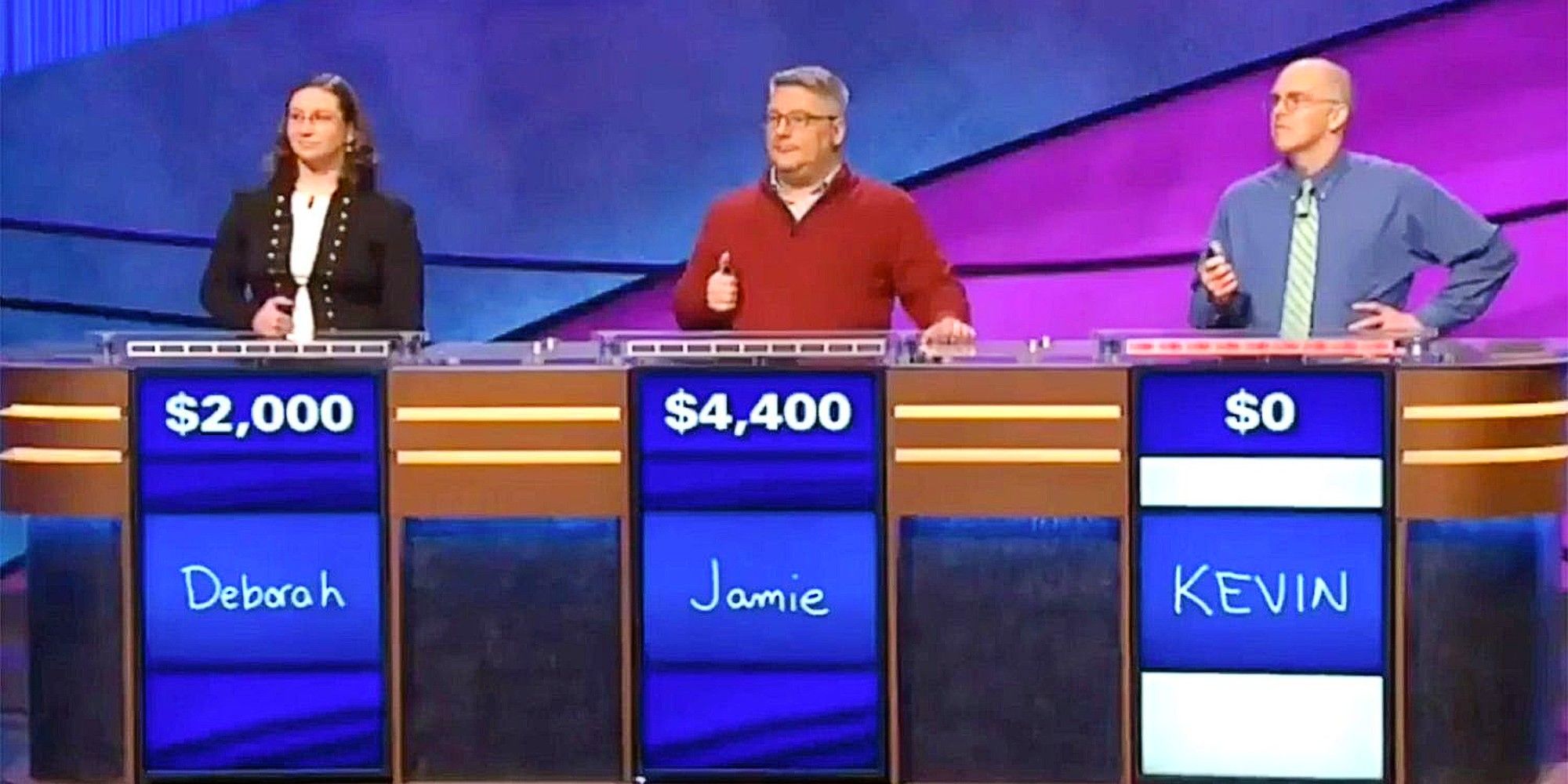 Deborah, Jamie y Kevin suben al podio y compiten en Jeopardy con sus nombres y cantidades escritas en ellos.