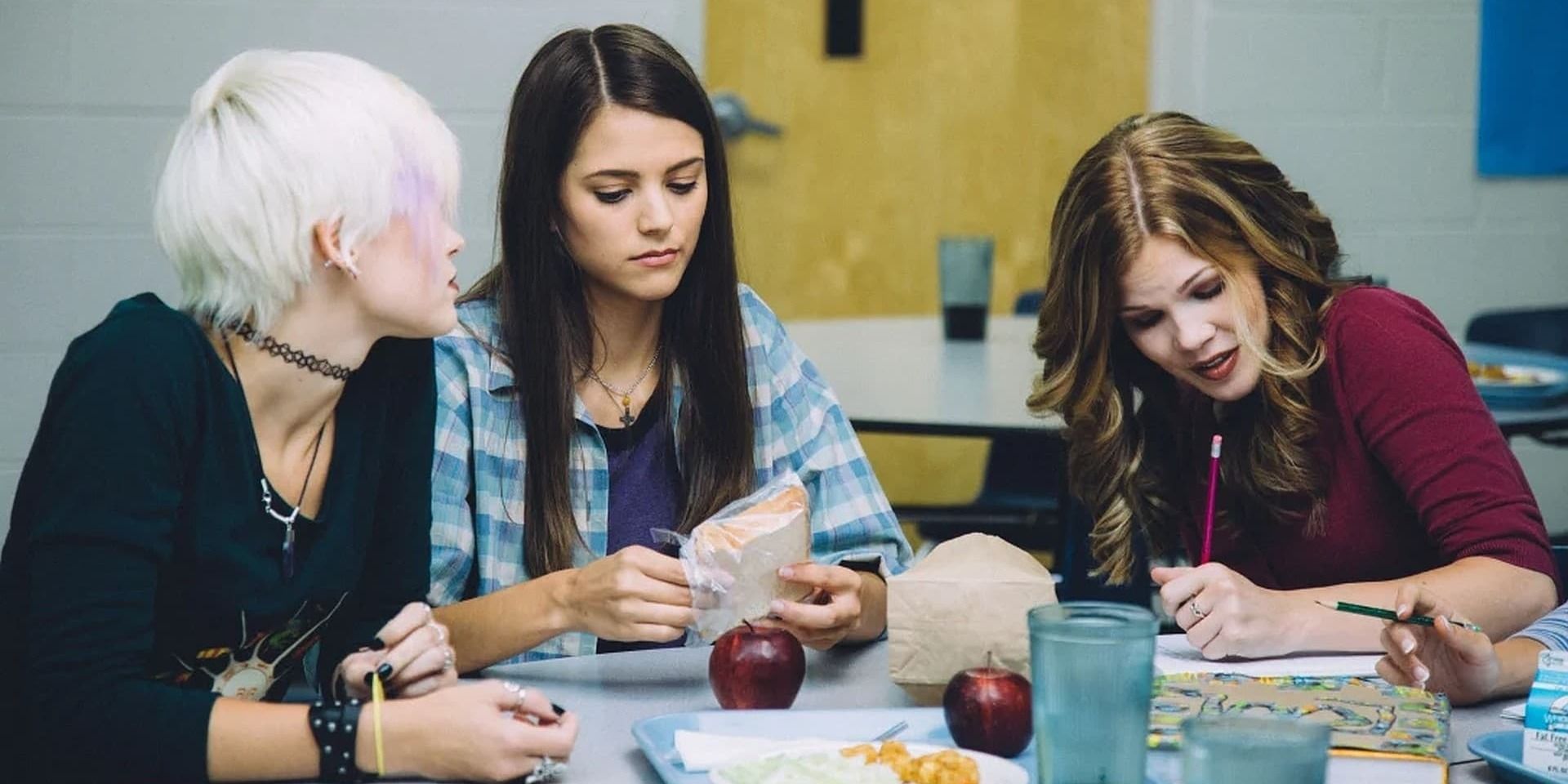 A trio of teenage girls sitting at the lunch table together in 'I'm Not Ashamed' (2016)