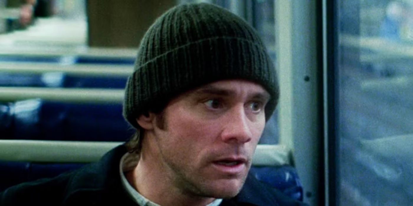 Jim Carrey as Joel wearing a beanie looking out a window on a bus in Eternal Sunshine of the Spotless Mind.