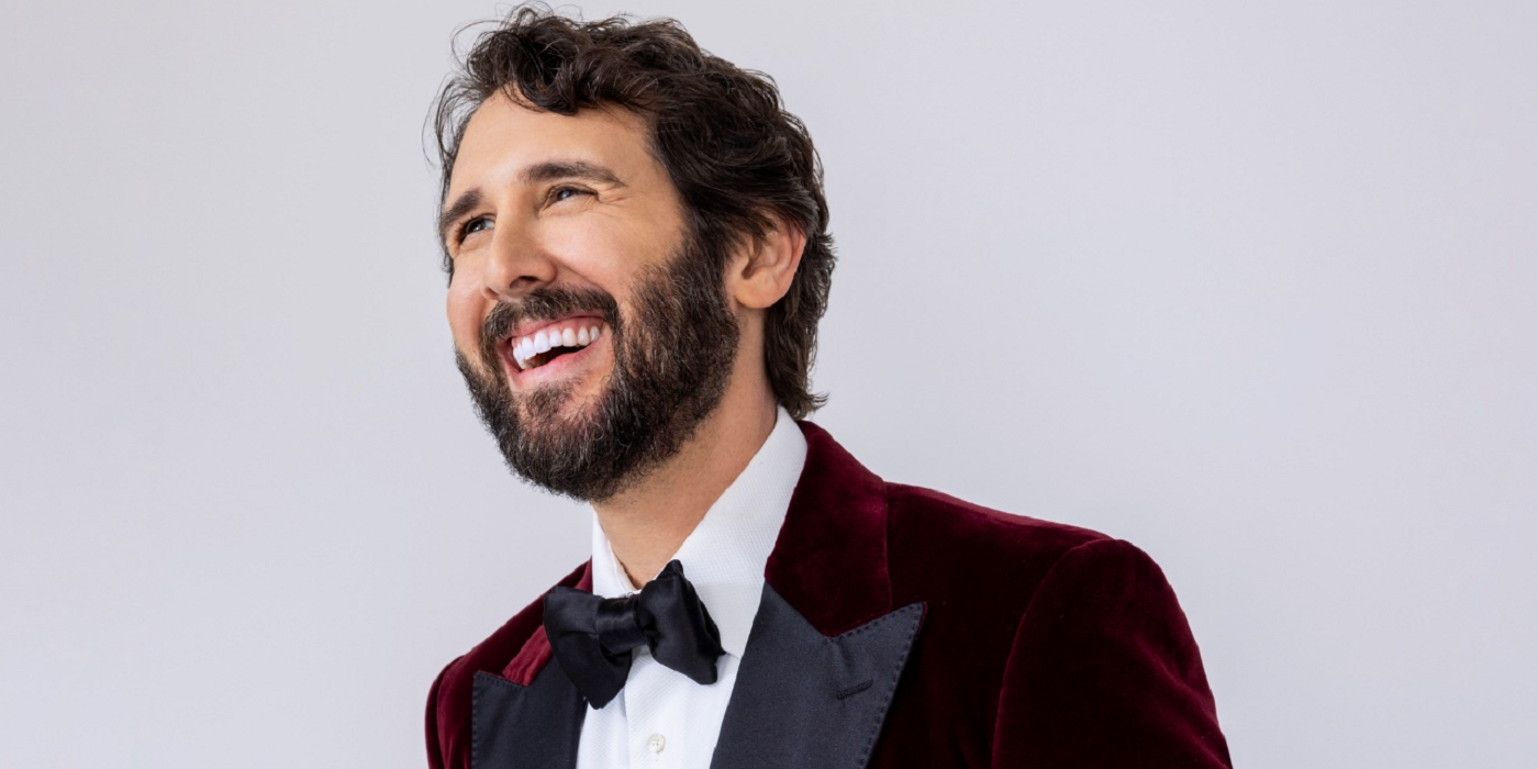 Josh Groban smiling for a promo shoot for Josh Groban &amp; Friends Go Home For The Holidays