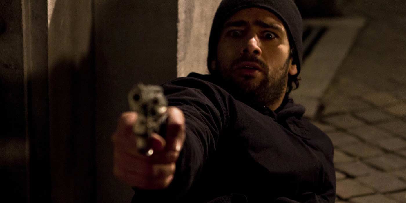 Kevyn Diana on the ground pointing a gun in Being