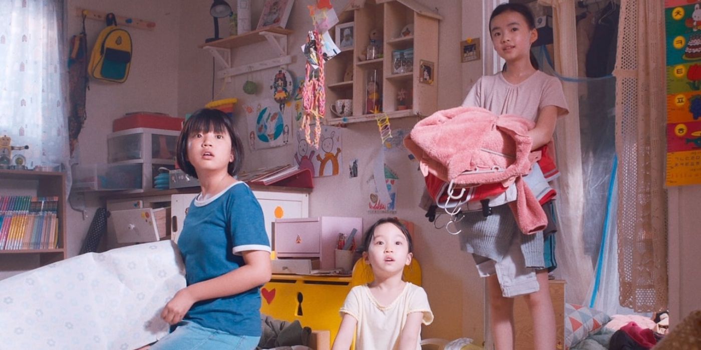 Three young girls look in awe at something off camera while playing in a bedroom in The House of Us (2019).