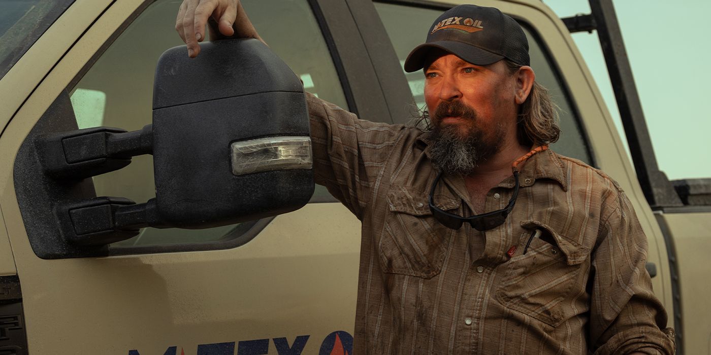 James Jordan with his hand on the mirror of his truck looking into the sunset 