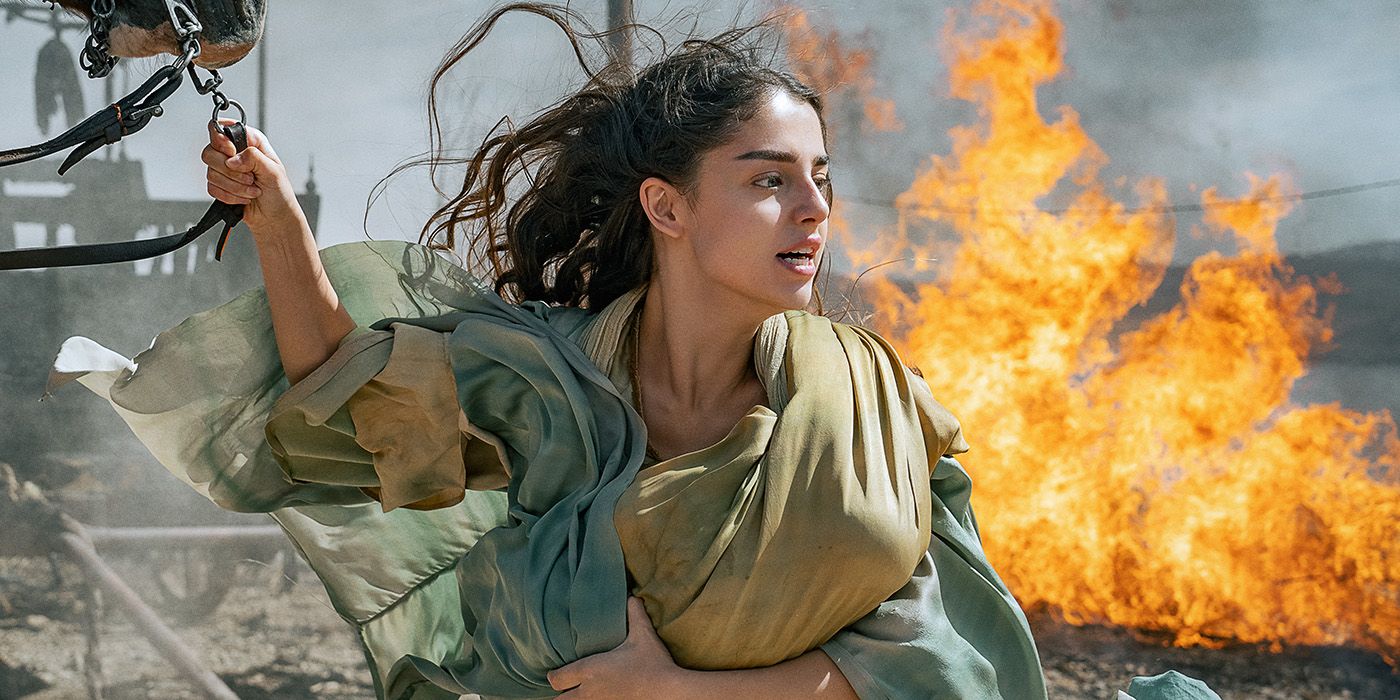 Noa Cohen as Mary holding a baby and running from a fire in Mary 