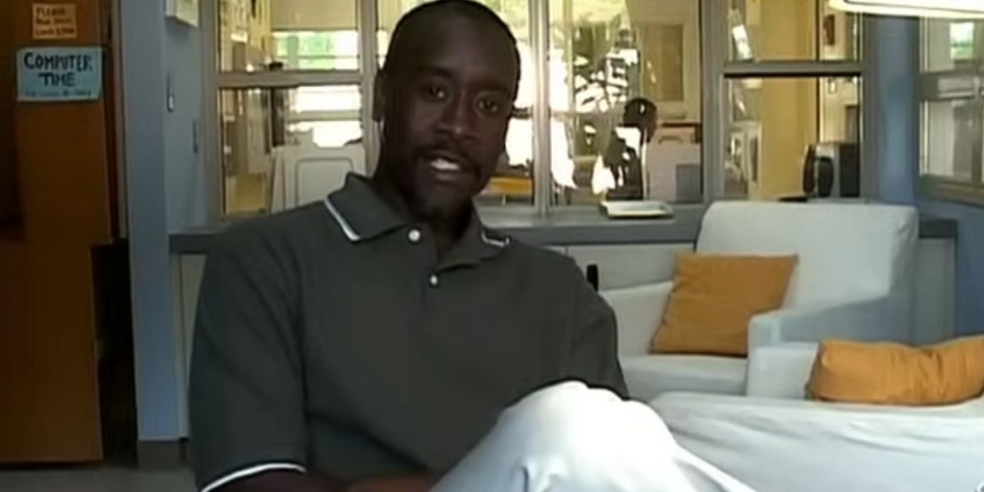 Don Cheadle as Dr. Monroe looking at the camera with his legs crossed